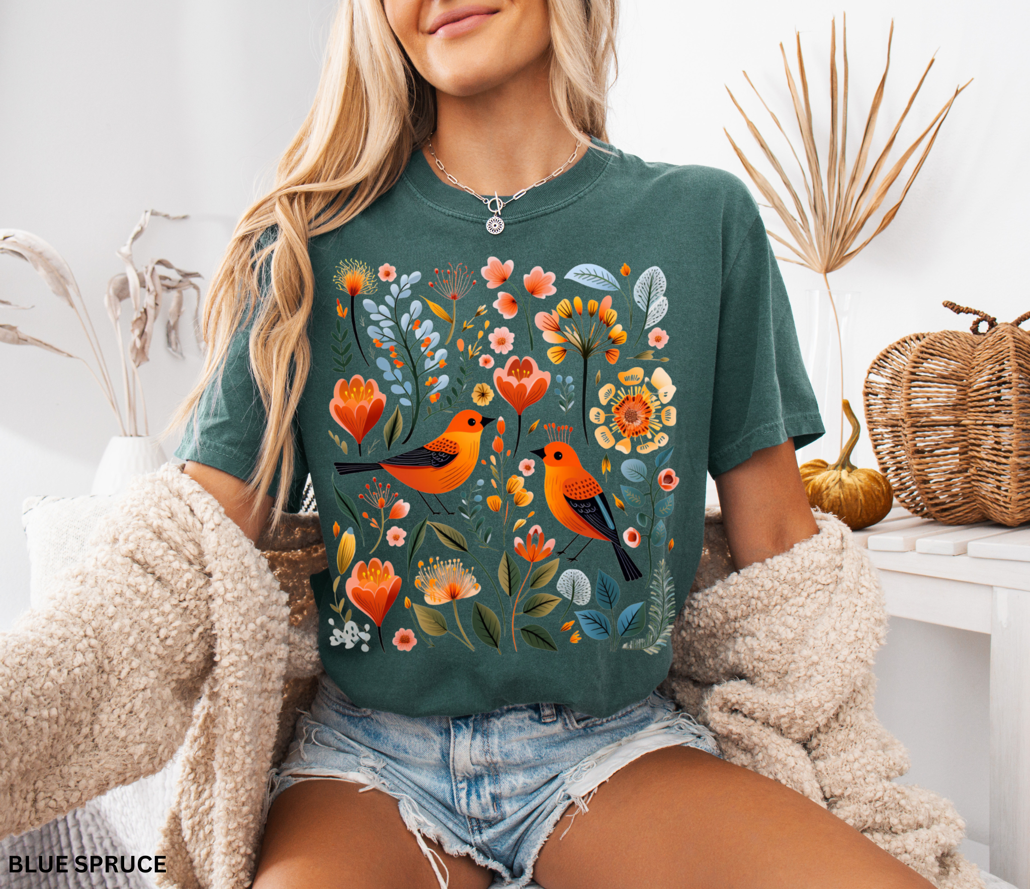 Scandinavian folk art design with two orange songbirds surrounded by blue and orange flowers in a Nordic floral pattern.