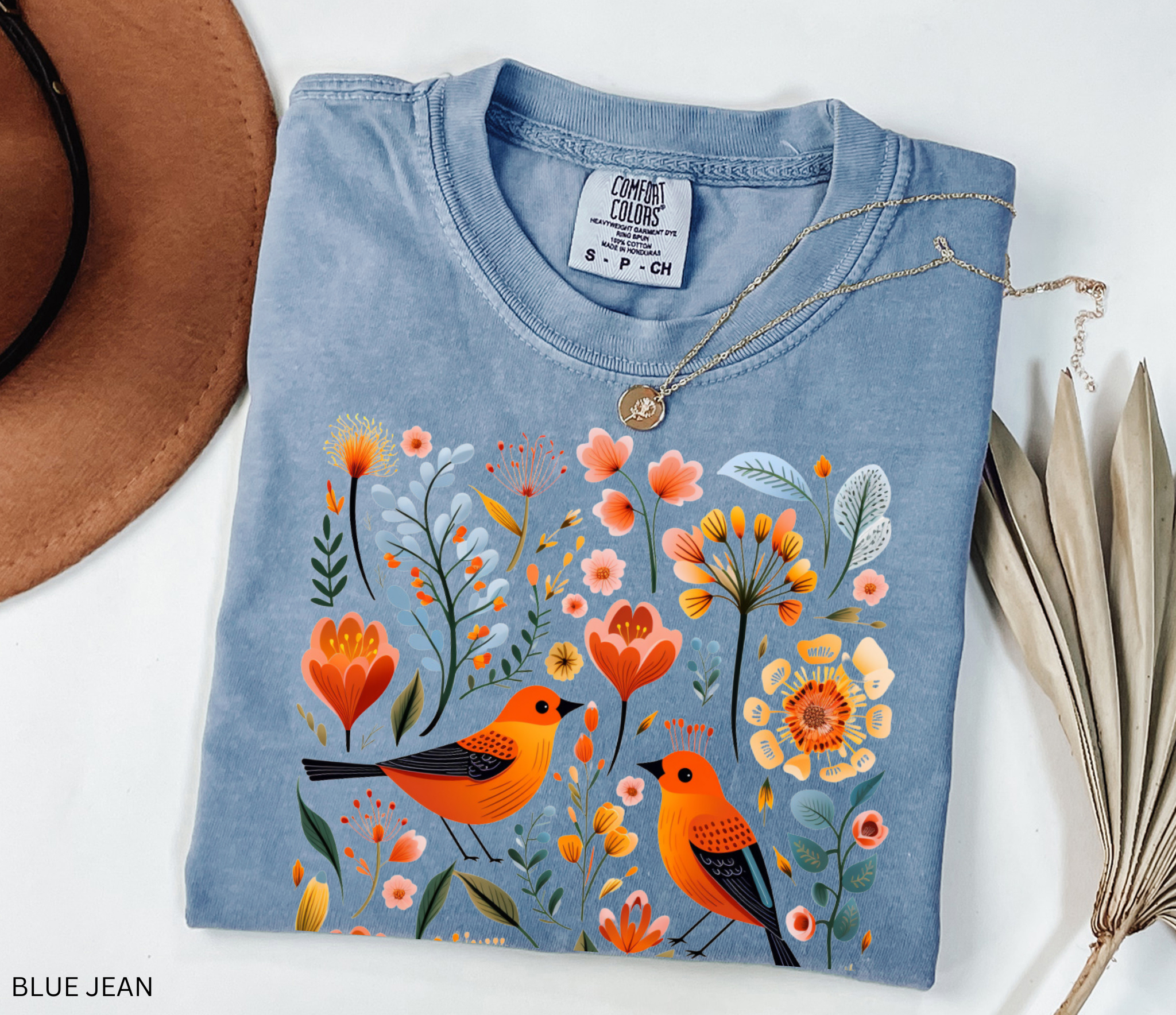 Scandinavian folk art design with two orange songbirds surrounded by blue and orange flowers in a Nordic floral pattern.