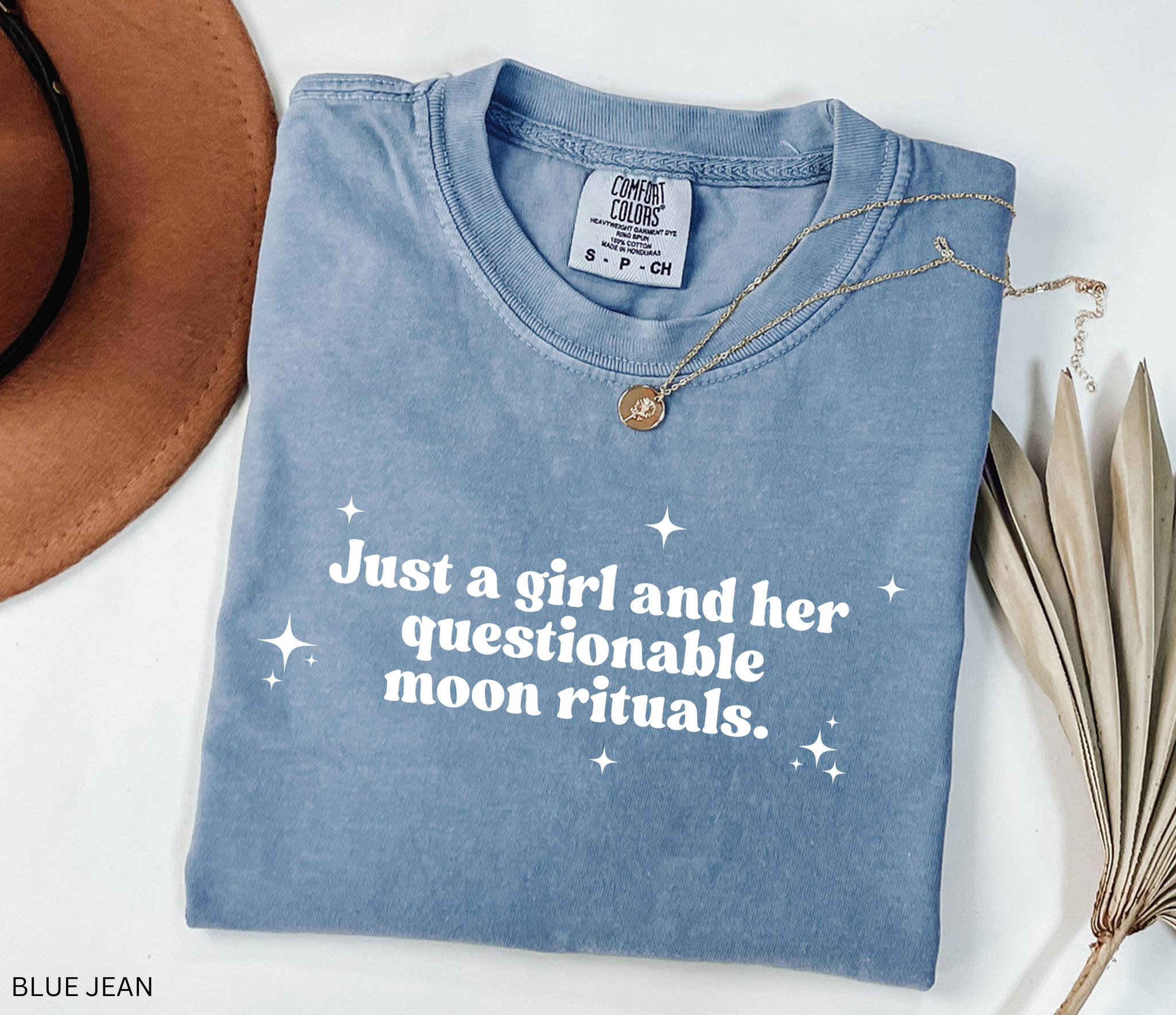 Funny witchy shirt design reading “Just a girl and her questionable moon rituals” with sparkly stars around the text.
