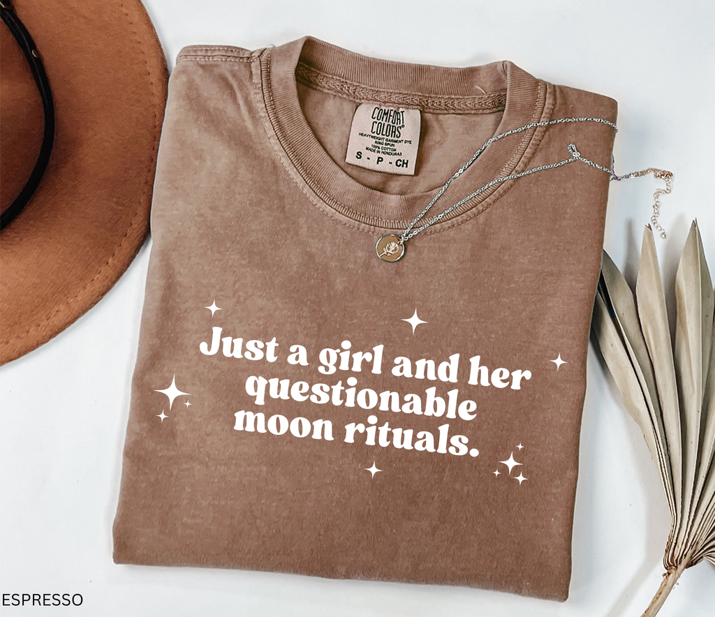 Funny witchy shirt design reading “Just a girl and her questionable moon rituals” with sparkly stars around the text.