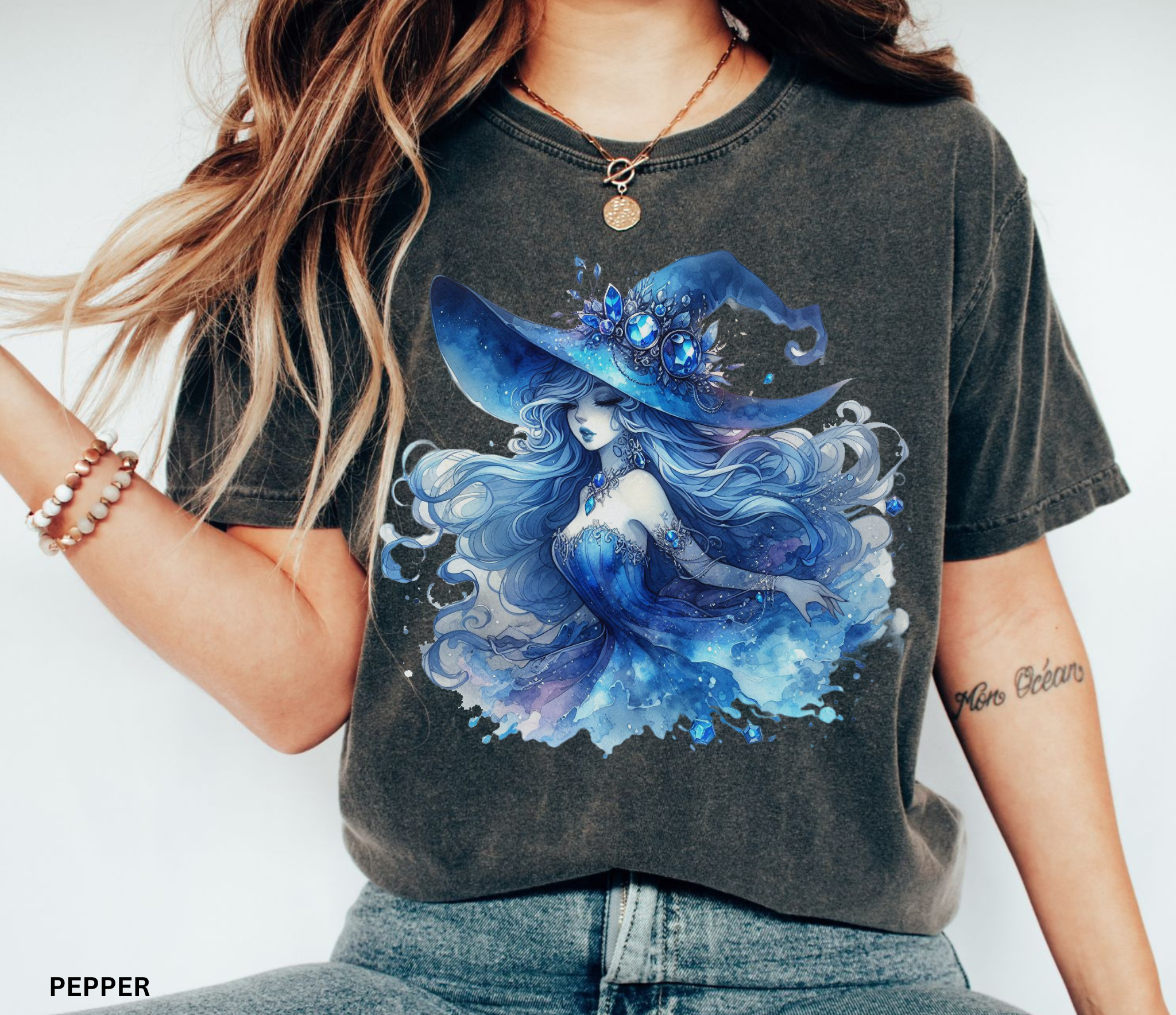 Watercolor fantasy illustration of a moonlit sapphire witch with flowing silver-blue hair, glowing gemstone jewelry, and a large enchanted blue hat surrounded by magical celestial details in a whimsical fairycore style.