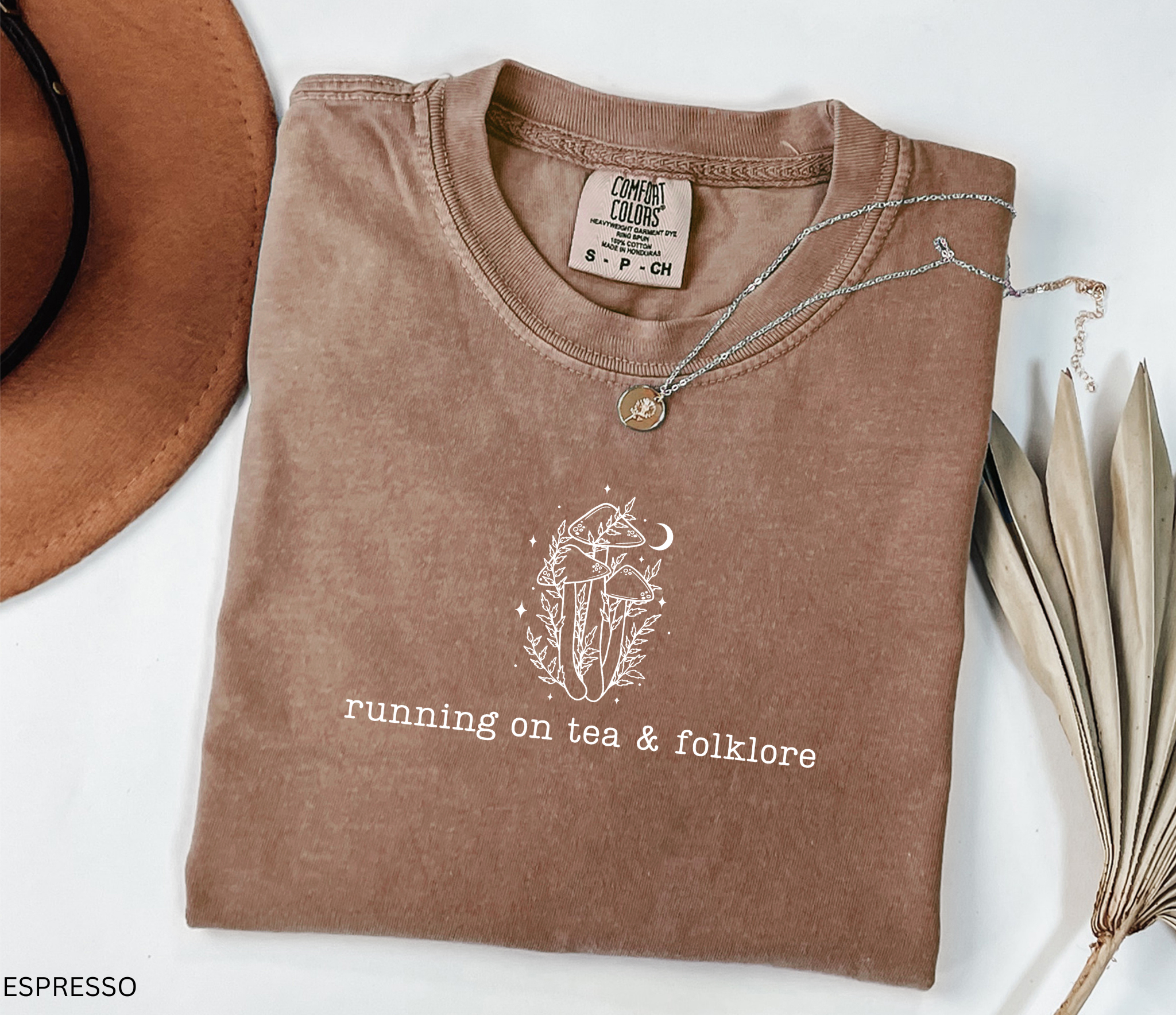 Minimalist whimsical mushroom illustration with moon details and the phrase “running on tea & folklore” in a cottagecore witchy aesthetic design.