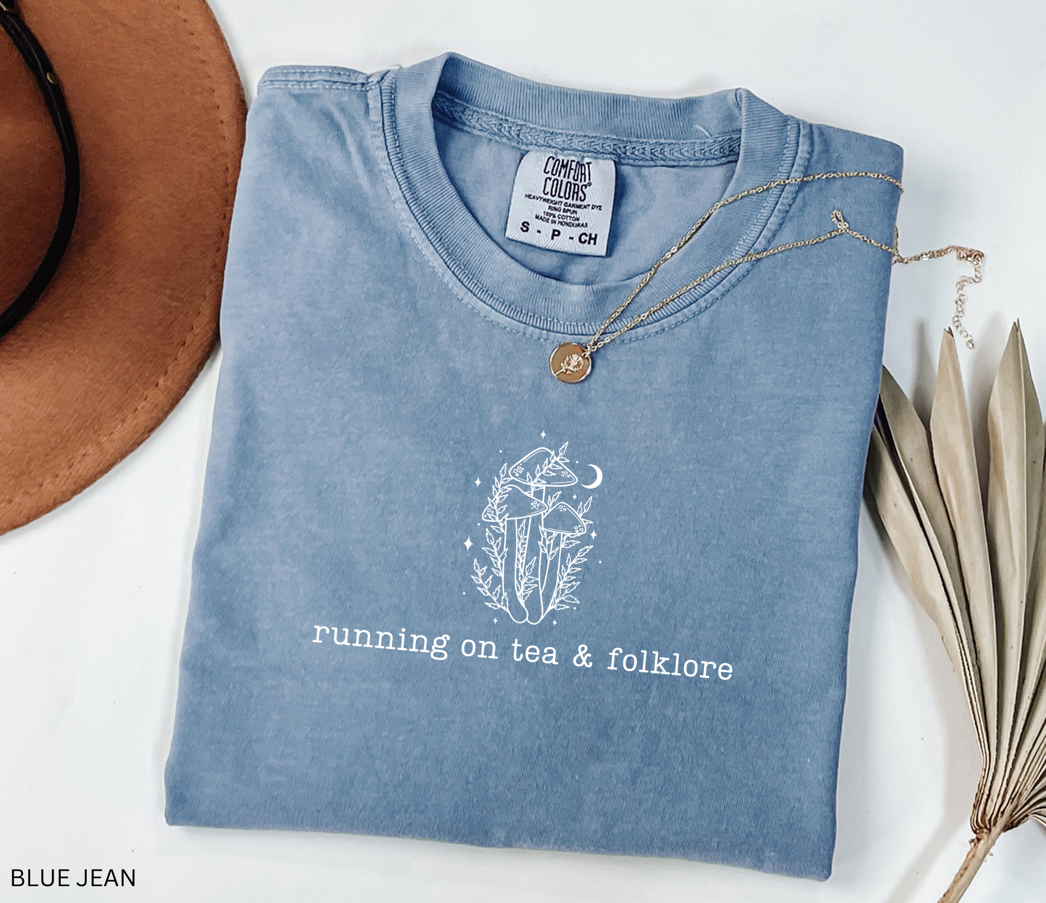 Minimalist whimsical mushroom illustration with moon details and the phrase “running on tea & folklore” in a cottagecore witchy aesthetic design.