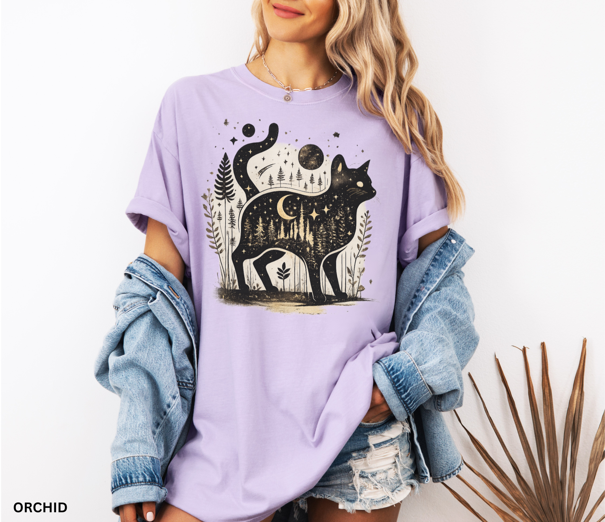 Comfort Colors cottagecore shirt featuring a magical black cat silhouette filled with a moonlit forest scene, stars, crescent moon, and woodland details. Available in orchid, blue jean, espresso, and ivory colors.