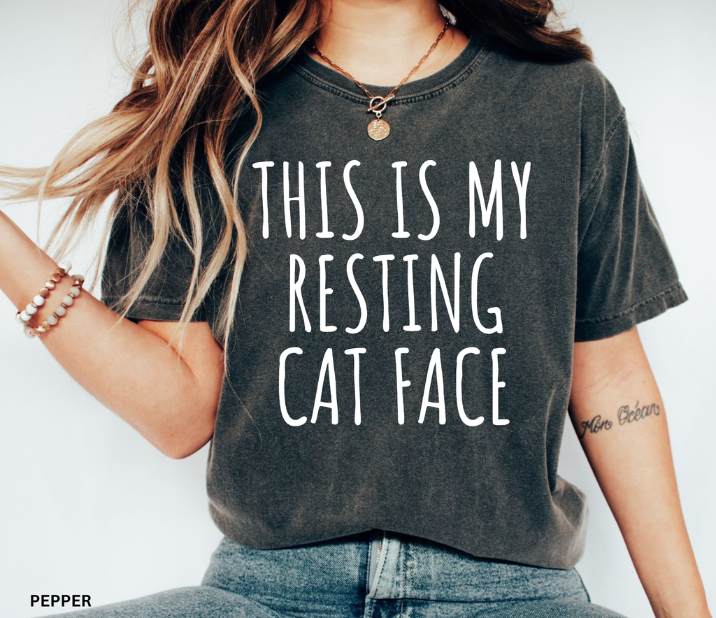 Black shirt featuring the phrase "This Is My Resting Cat Face" in bold white lettering, perfect for cat lovers and humorous everyday wear.