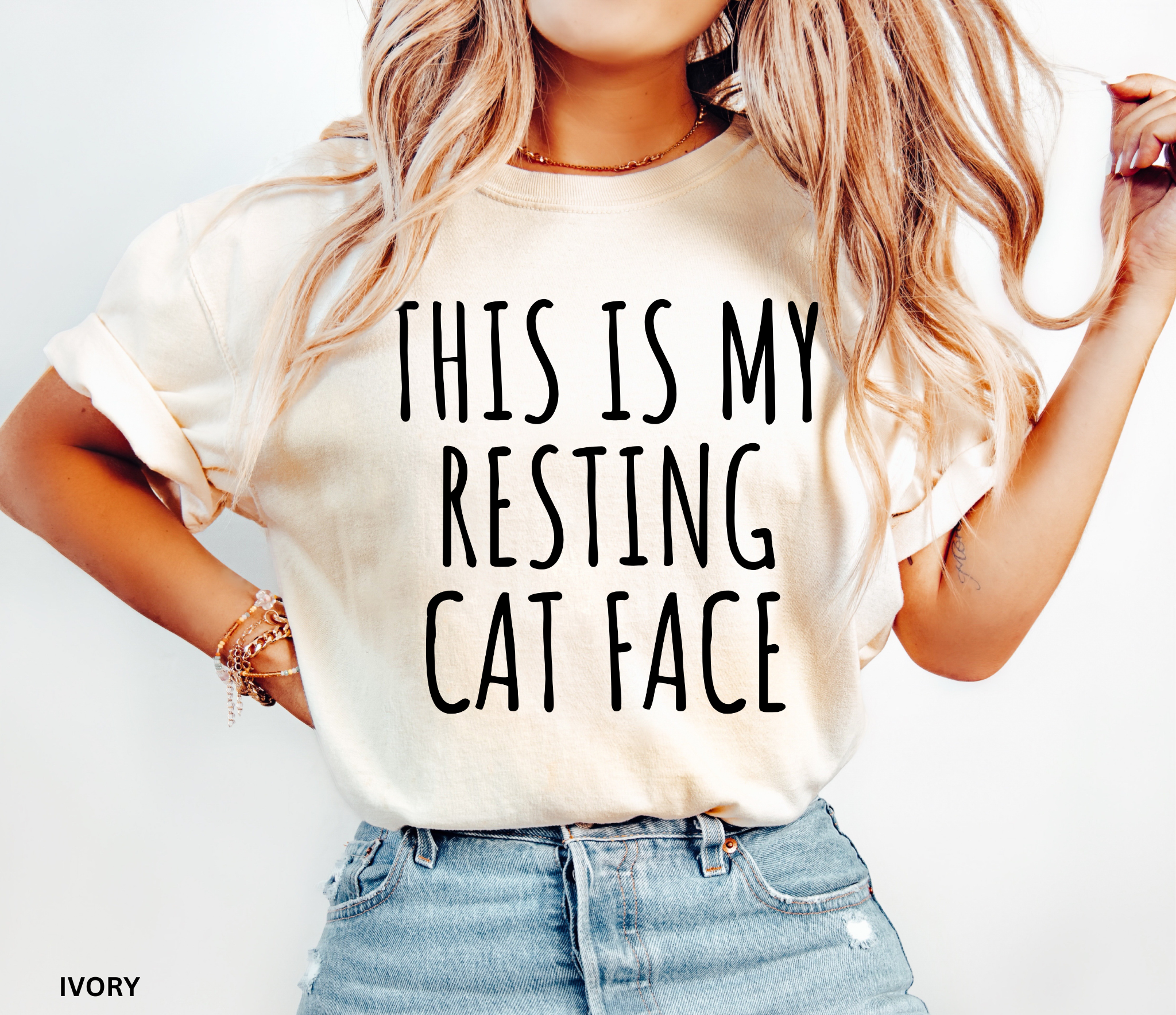 Person wearing a white t-shirt with 'THIS IS MY RESTING CAT FACE' text, standing against a plain background.