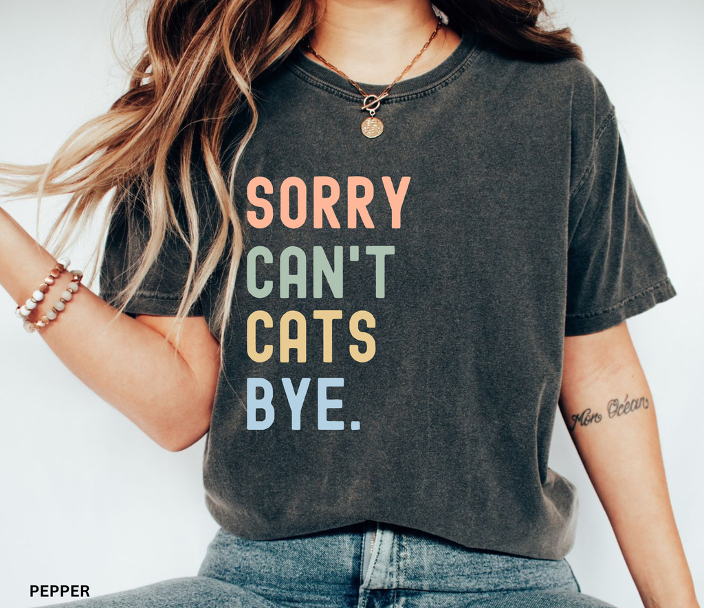 Retro pastel "Sorry Can't Cats Bye" graphic t-shirt featuring colorful vintage lettering for cat lovers, introverts, and proud cat moms.