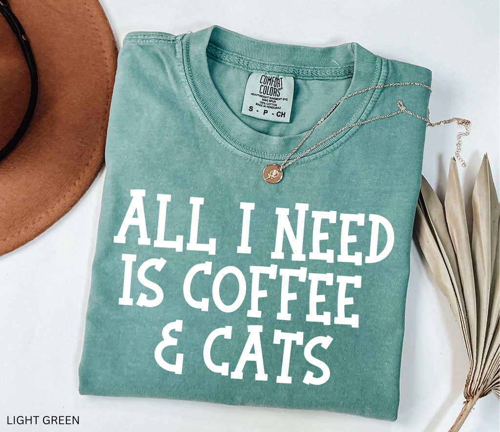 Comfort Colors graphic t-shirt featuring the phrase "All I Need Is Coffee & Cats" in bold vintage lettering, perfect for coffee lovers, cat moms, and animal lovers.