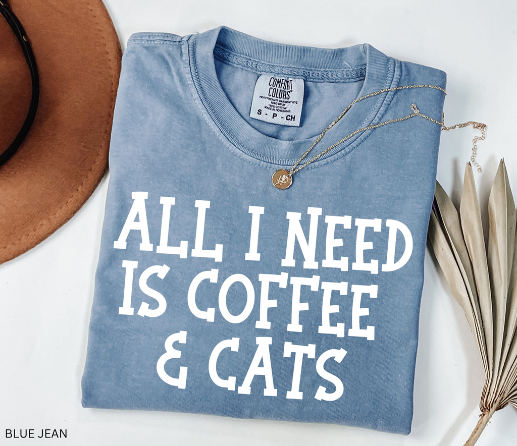 Comfort Colors graphic t-shirt featuring the phrase "All I Need Is Coffee & Cats" in bold vintage lettering, perfect for coffee lovers, cat moms, and animal lovers.