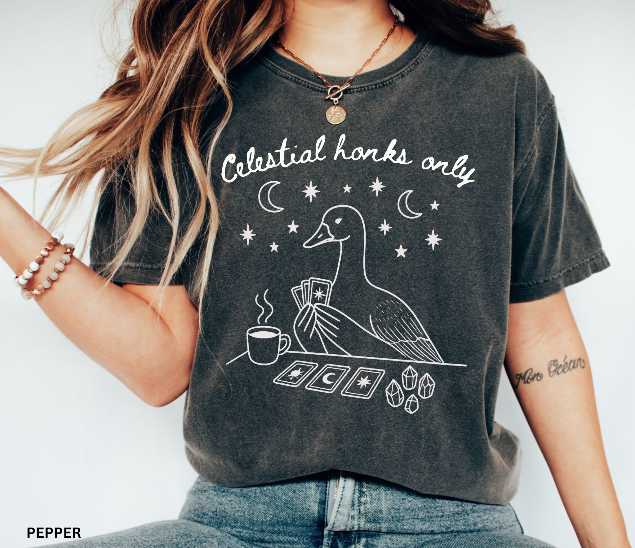 Funny witchy goose graphic featuring a celestial goose holding tarot cards beside a steaming cup of tea, surrounded by stars, crescent moons, and crystals. The design includes the phrase "Celestial Honks Only," making it a whimsical cottagecore and tarot-inspired shirt for goose lovers, tea drinkers, and mystical souls.