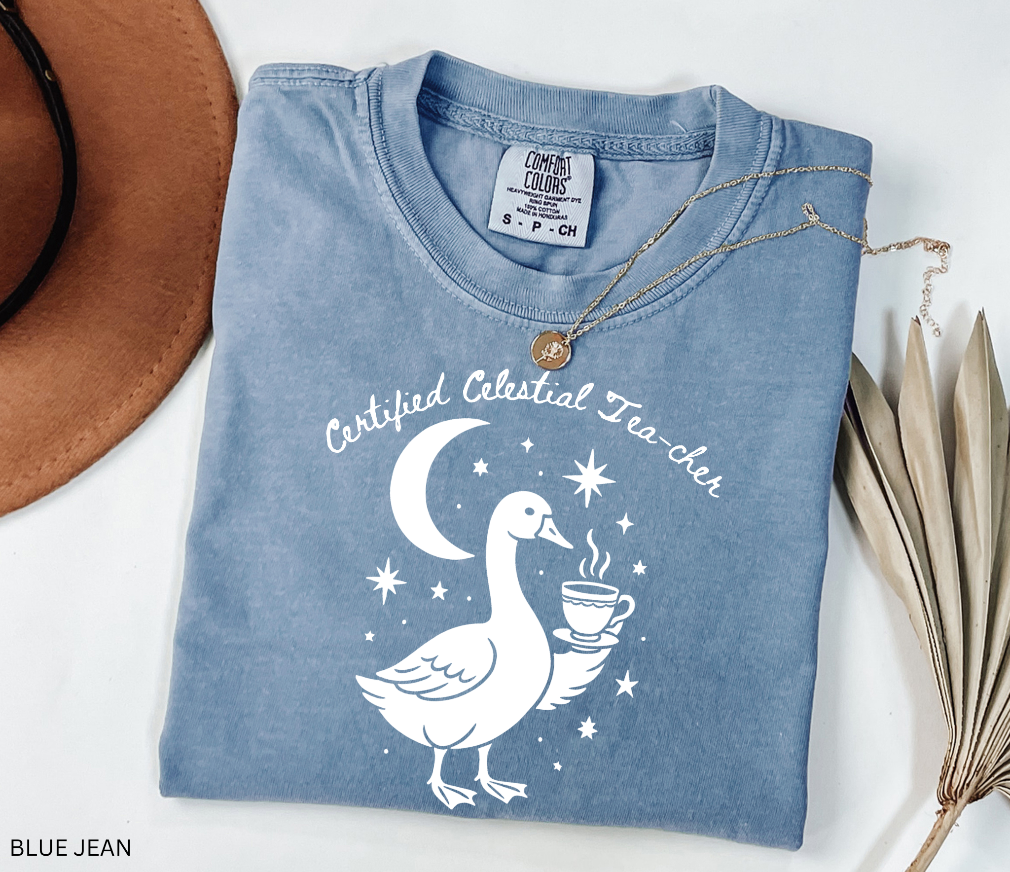 Certified Celestial Tea-cher Comfort Colors t-shirt featuring a whimsical goose holding a steaming teacup beneath a crescent moon and stars, perfect for witchy teachers, tea lovers, and cottagecore fashion.