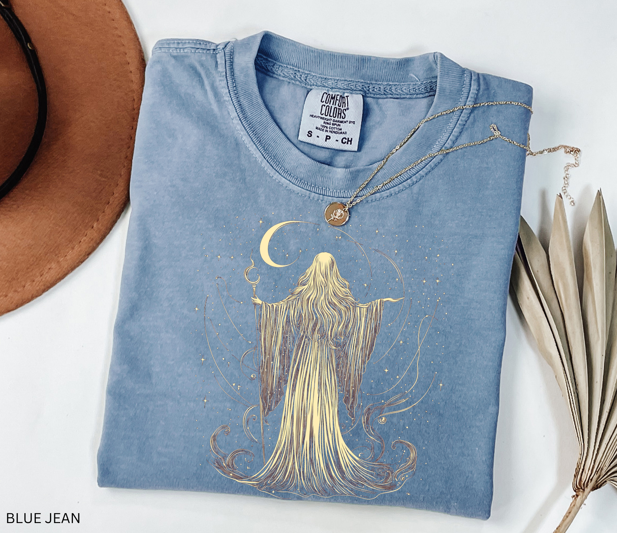 Vintage Comfort Colors t-shirt featuring an elegant moon priestess standing beneath a crescent moon surrounded by stars and flowing celestial magic. Available in Blue Jean, Espresso, Pepper, and Black.