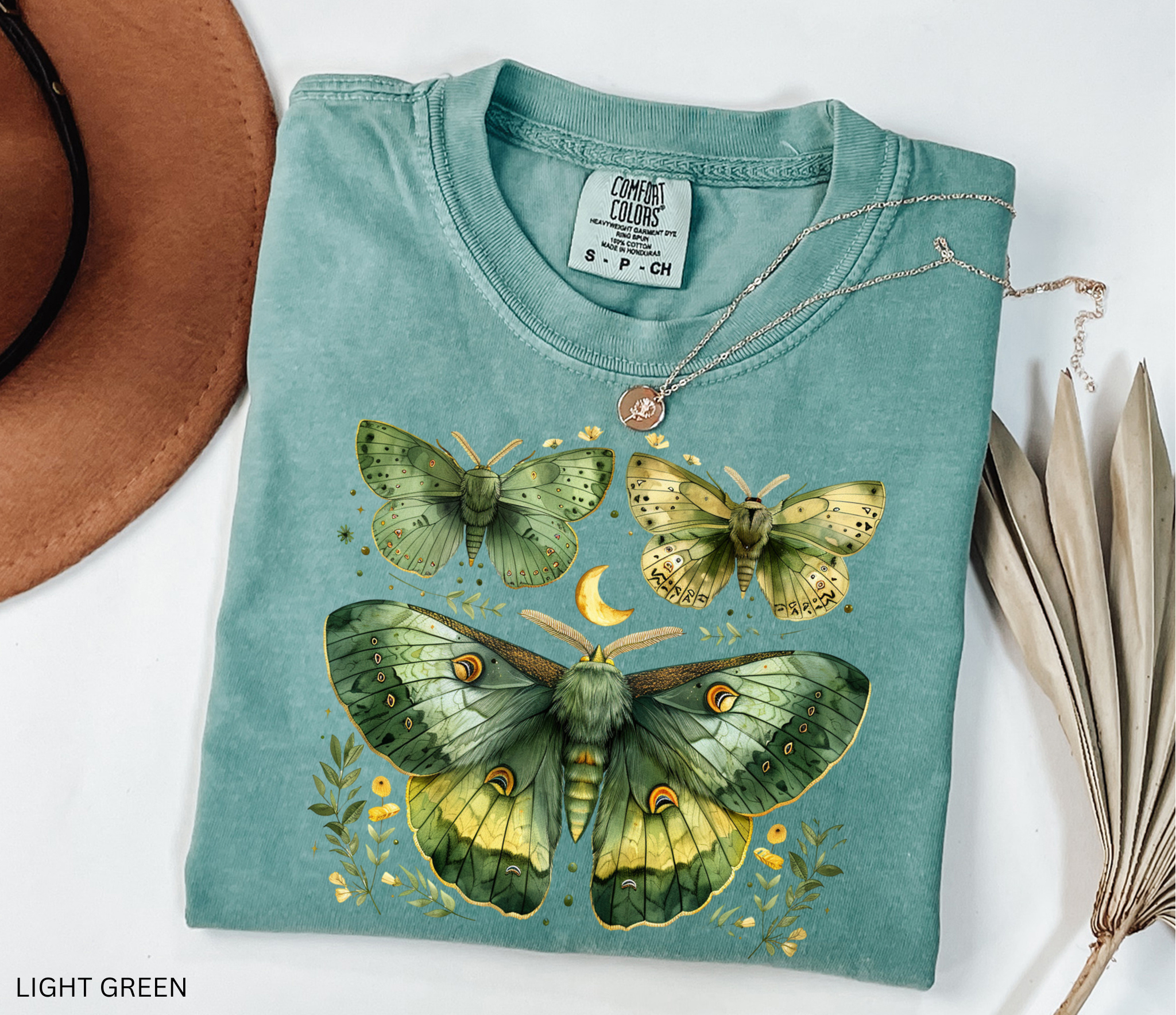 Light green Comfort Colors t-shirt with green luna moths, crescent moon and botanical floral design