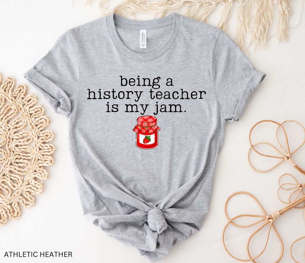 Shop the “Being a History Teacher Is My Jam” shirt featuring a cute strawberry jam design. A funny history teacher tee for school outfits, teacher gifts and back to school.