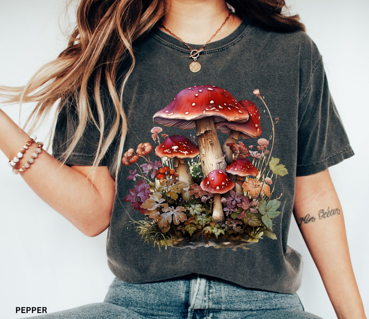 Red mushroom graphic t-shirt featuring a detailed cluster of woodland toadstools surrounded by autumn foliage and botanical details.