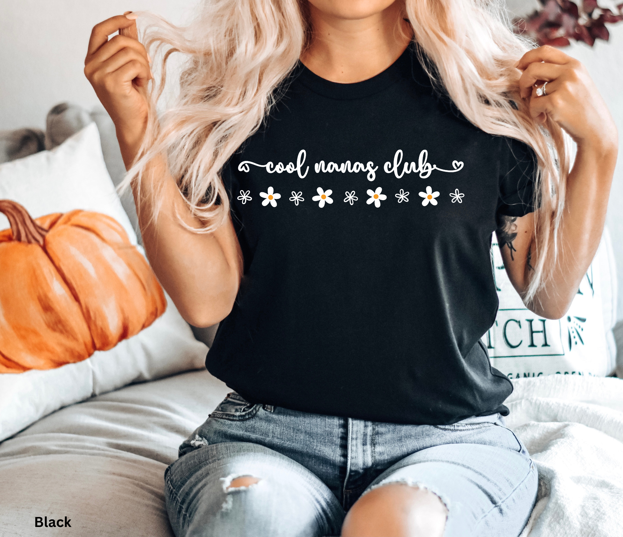 Script text reading “cool nanas club” with small daisy illustrations in white and yellow on a black background.