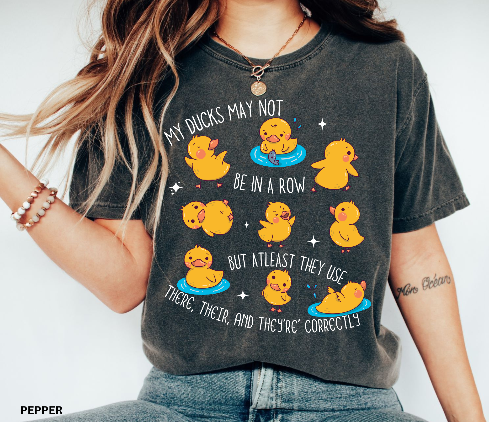 Playful duck illustration with the phrase ‘My ducks may not be in a row, but at least they use there, their, and they’re correctly,’ designed as a humorous shirt for English teachers.