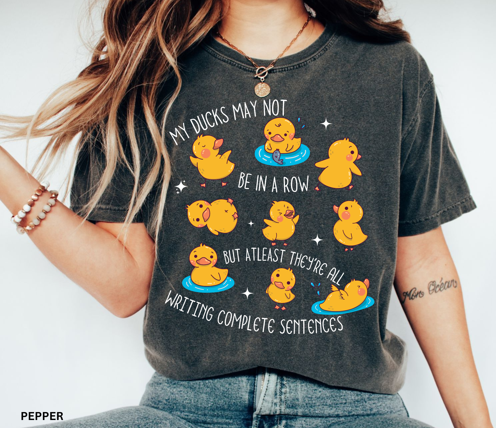 Playful duck illustration with the phrase ‘My ducks may not be in a row, but at least they’re all writing complete sentences,’ designed as a humorous shirt for English teachers.