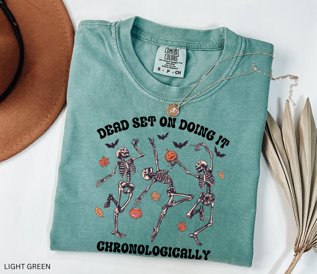 History teacher Halloween shirt with dancing skeletons, pumpkins, bats, and autumn leaves. Funny spooky season tee for teachers and classrooms.