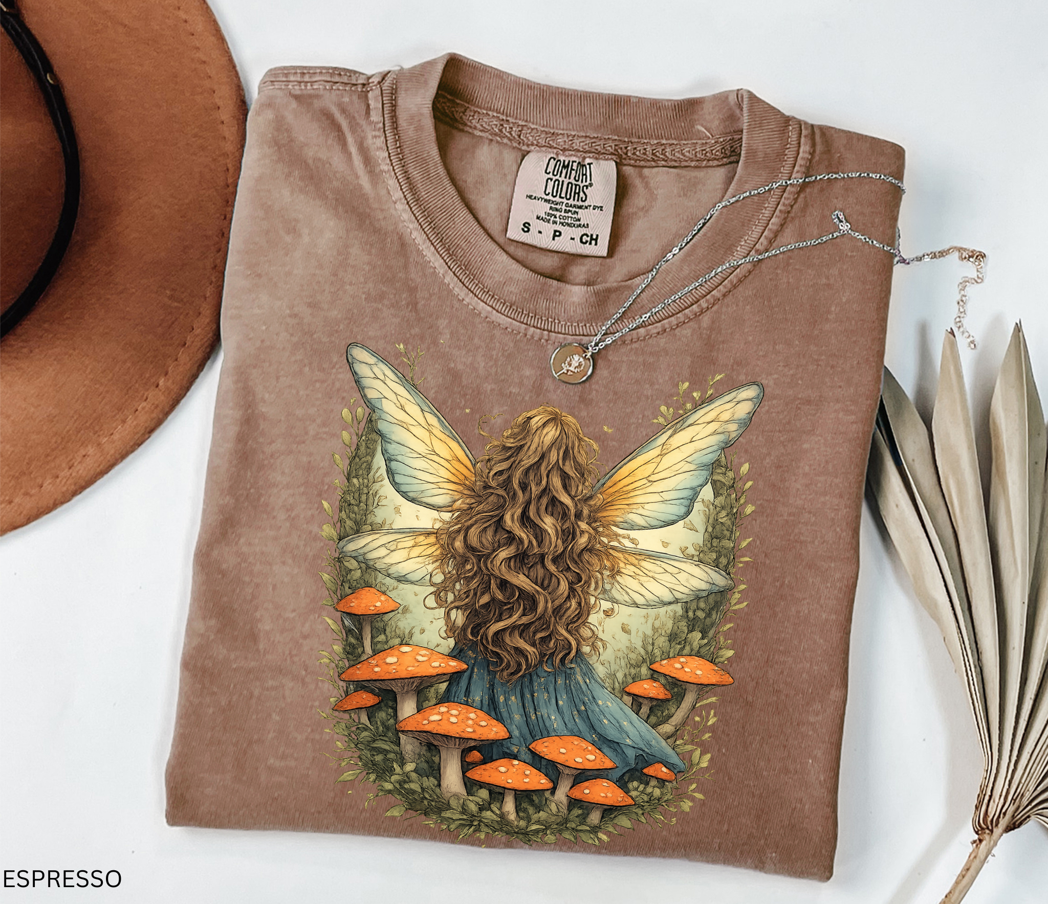 Whimsical fairy girl with glowing wings surrounded by orange mushrooms in an enchanted forest, cottagecore fairycore aesthetic shirt design.