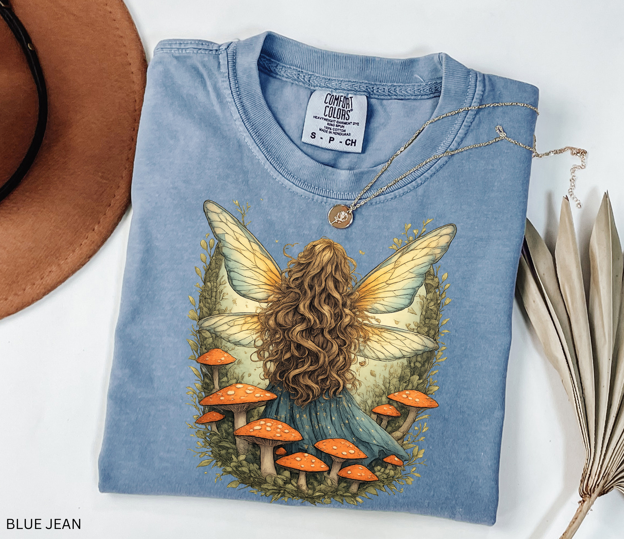 Whimsical fairy girl with glowing wings surrounded by orange mushrooms in an enchanted forest, cottagecore fairycore aesthetic shirt design.