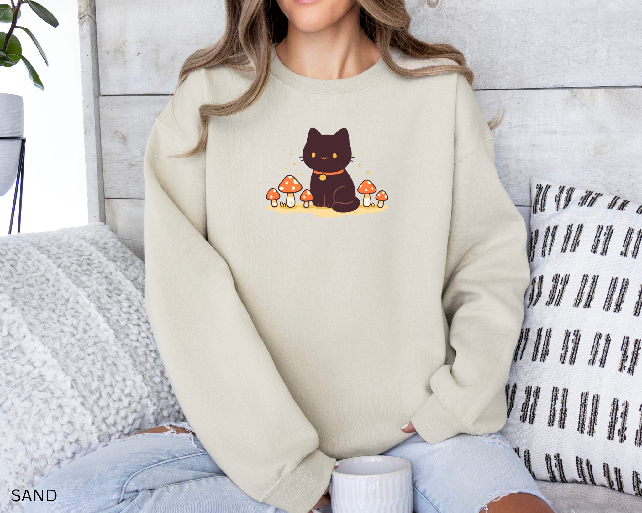 A cozy Comfort Colors sweatshirt featuring a cute black cat sitting among red mushrooms, perfect for cottagecore and witchy aesthetic lovers.