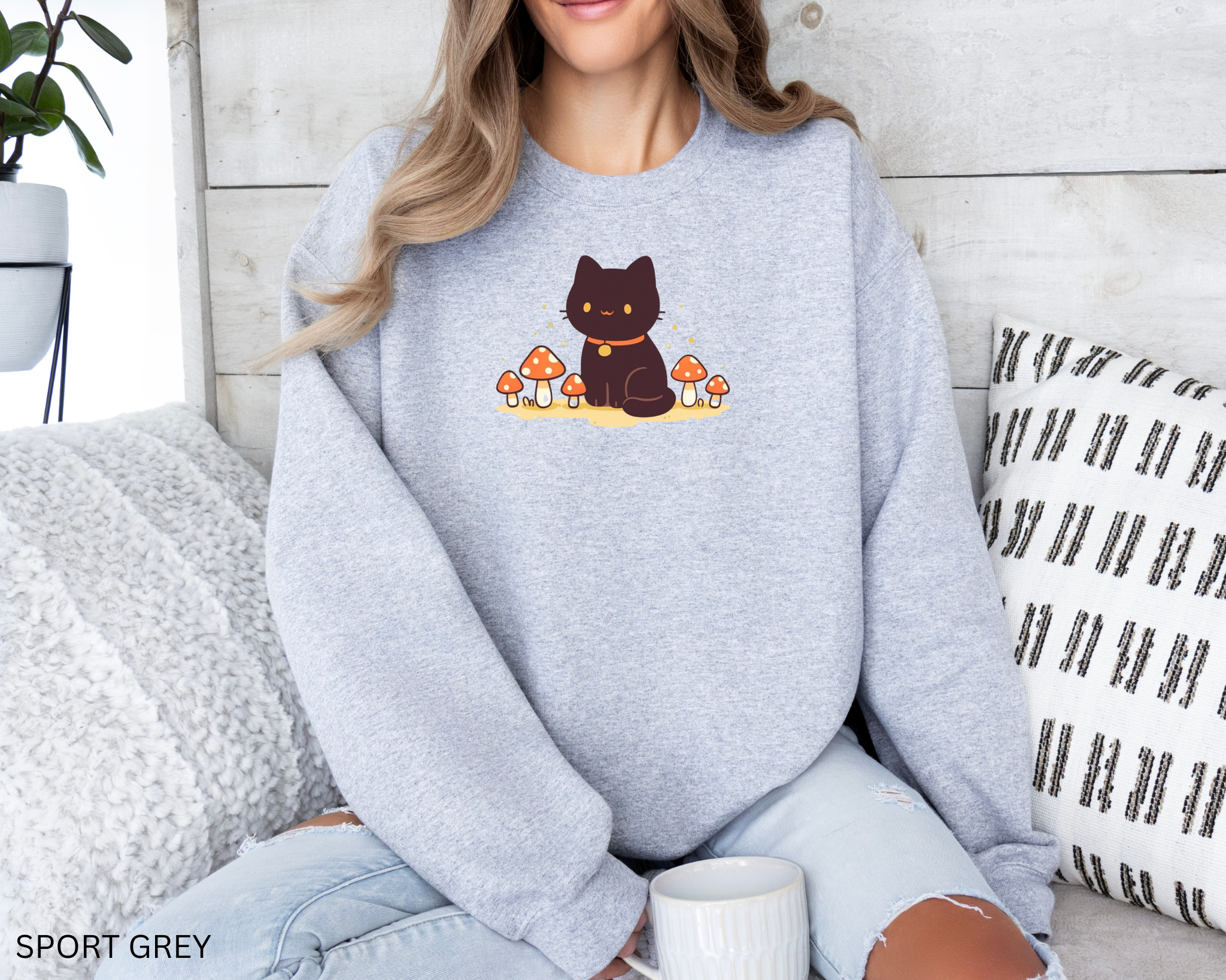 A cozy Comfort Colors sweatshirt featuring a cute black cat sitting among red mushrooms, perfect for cottagecore and witchy aesthetic lovers.