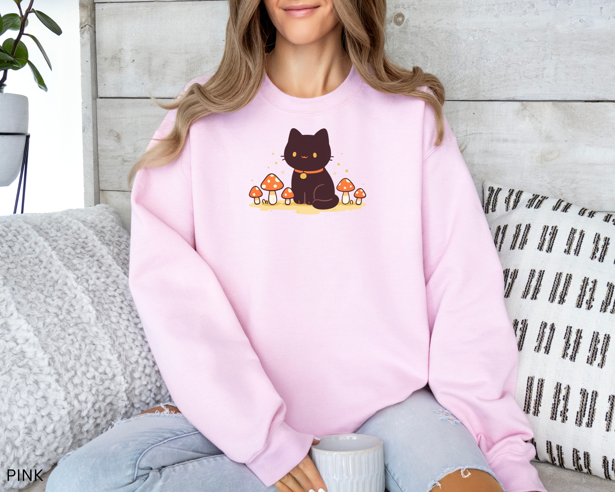 A cozy Comfort Colors sweatshirt featuring a cute black cat sitting among red mushrooms, perfect for cottagecore and witchy aesthetic lovers.