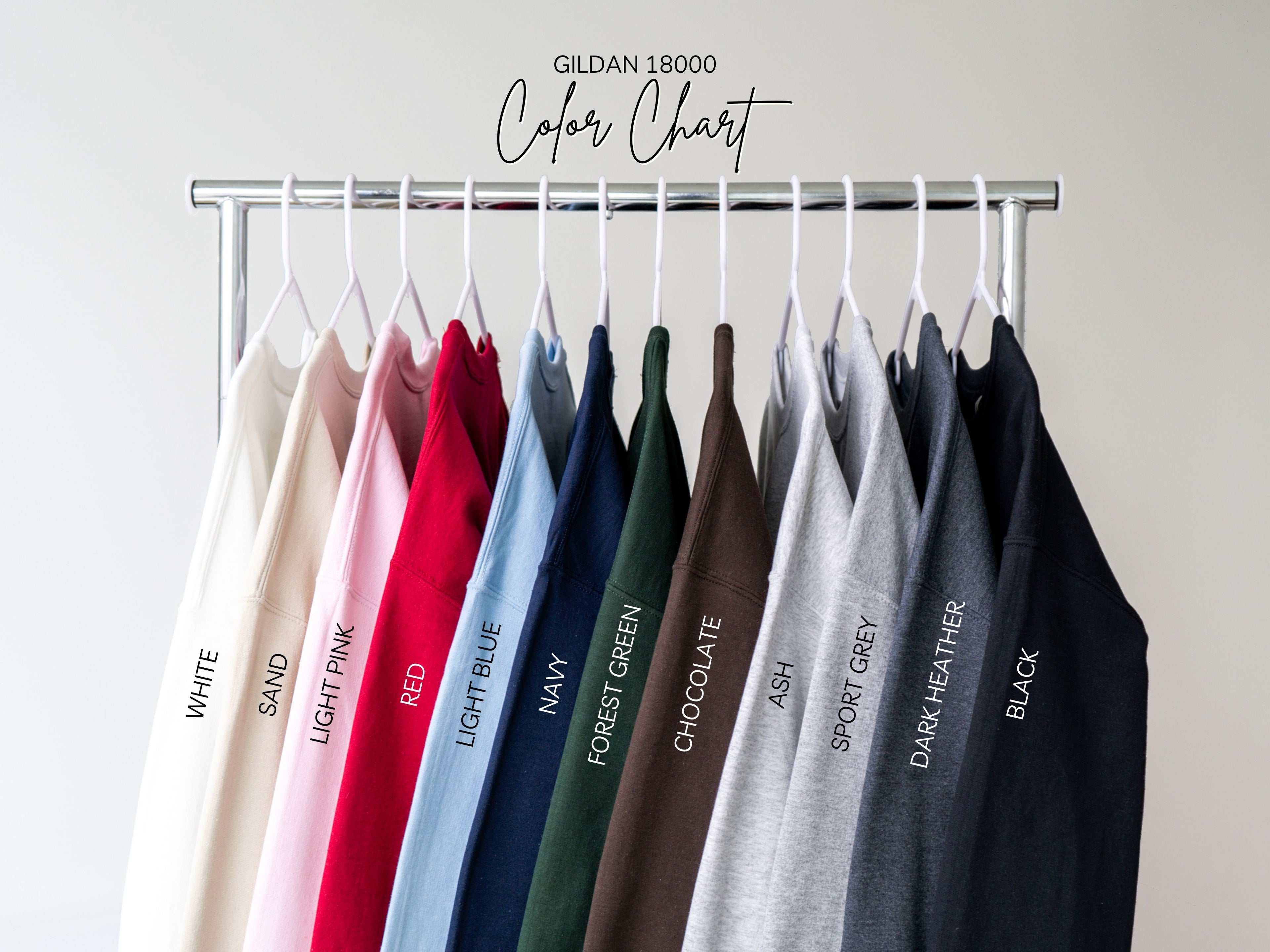 Color chart for Gildan 18000 t-shirts with various colors on hangers against a plain background.
